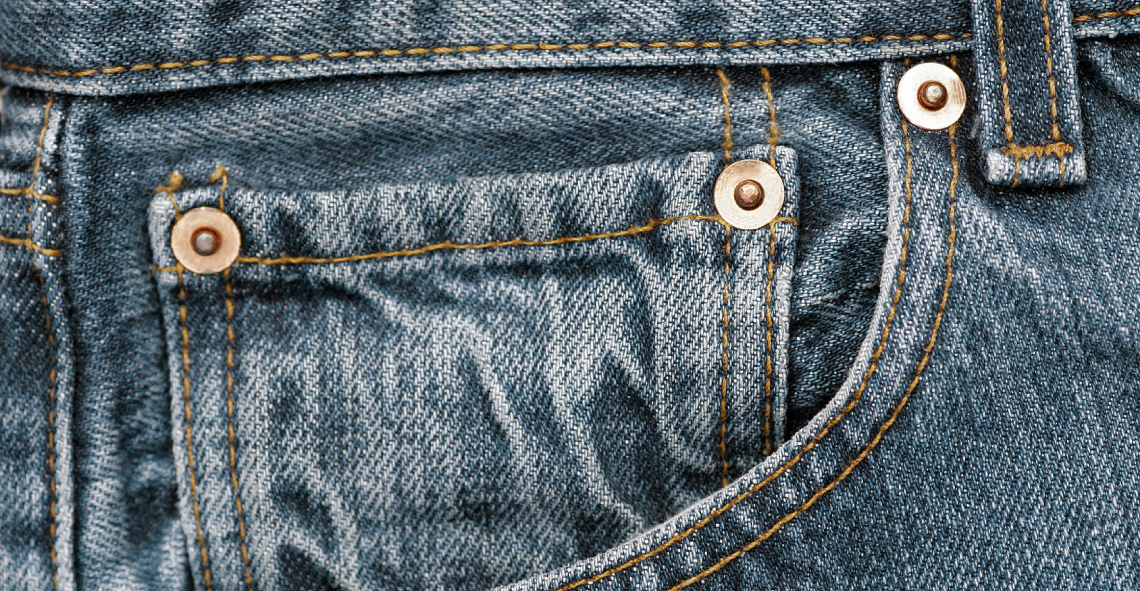 Bild von drei glänzenden Nieten auf einer Jeans