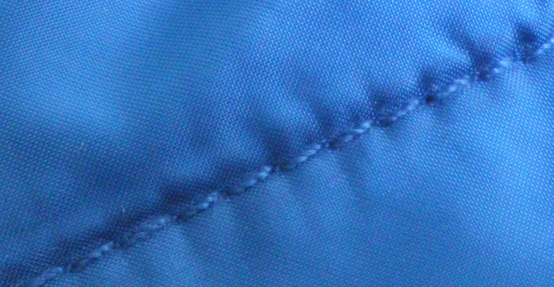 Bild eines blauen Gewebes mit Oil Bleeding an der blauen Naht